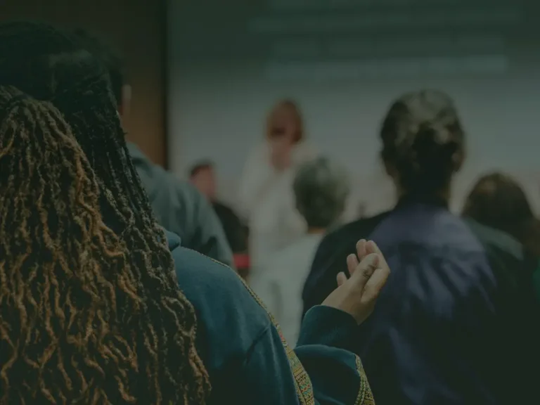 Woman in church singing with her hands raised